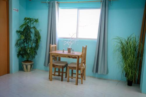 女人岛Casa del mar caribe的一间带桌子和两把椅子的用餐室以及窗户。