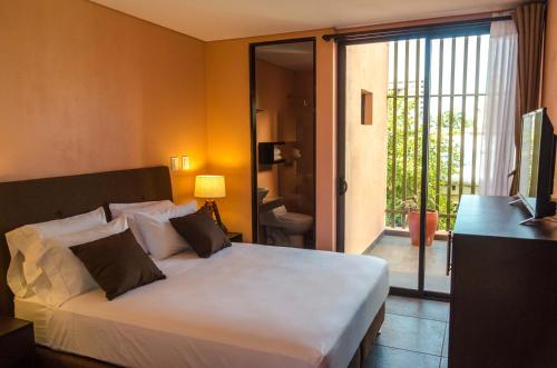 圣玛尔塔Oasis Fresh Hotel的一间带白色床的卧室和一个阳台