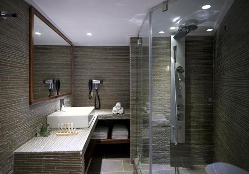 维蒂纳Art Mainalon Hotel的一间带水槽和淋浴的浴室