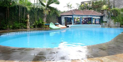 塞米亚克水明漾帕达迪索酒店的一座大型游泳池,游泳池的滑梯上坐着人