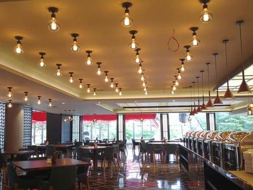 SadaoM Hotel Danok的用餐室配有桌椅和灯光