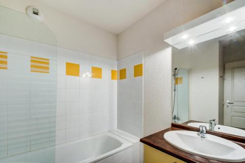 巴涅尔-德吕雄Vacancéole - Résidence Illixon的浴室配有盥洗盆和浴缸。