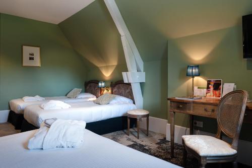 索隆拉吕Domaine de Saulon的酒店客房带两张床、书桌以及一间客房。