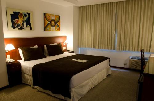 瓜亚基尔HM国际大酒店的一间设有大床和窗户的酒店客房