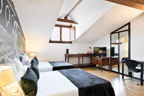 维多利亚-加斯特伊兹维多利亚阿巴爵士酒店的酒店客房设有两张床和电视。
