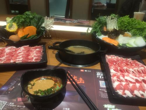 蓟州区天津市黄崖关长城家园酒店的桌上放着汤和蔬菜