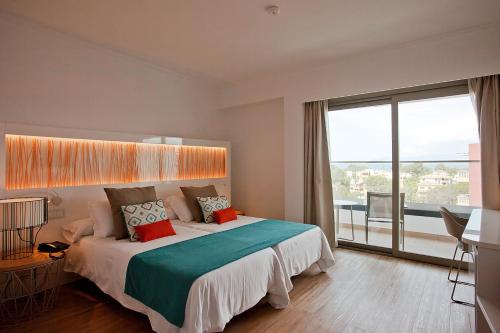 埃尔阿雷纳尔Hotel Ipanema Beach的一间卧室设有一张大床和一个大窗户