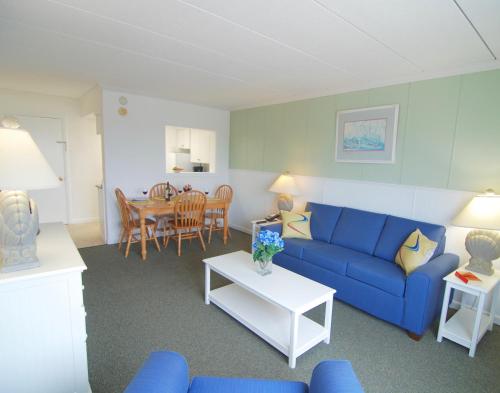 普罗温斯敦沙堡度假酒店的客厅配有蓝色的沙发和桌子