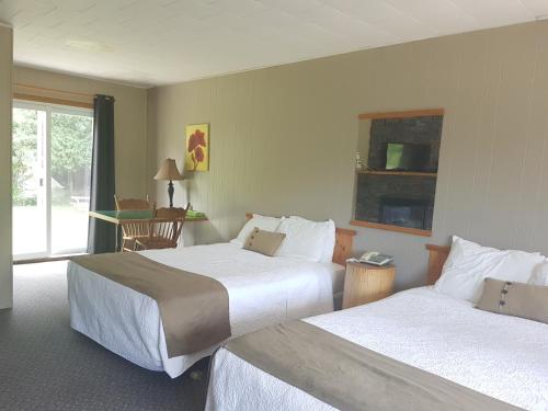 怀尔顿The Spirit Rock Outpost & Lodge的酒店客房设有两张床和窗户。