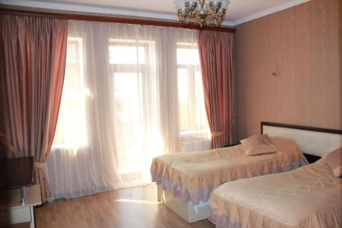 İvanovkaIvanovka Guest House的酒店客房设有两张床和窗户。