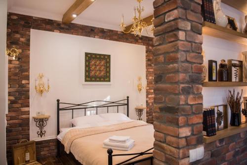 基希讷乌Vinodorum Apartments的一间卧室设有砖墙和一张床