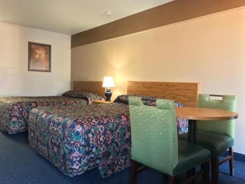 麦岭美国汽车旅馆的酒店客房带一张床、一张桌子和椅子