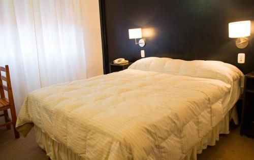 拉巴斯Hotel Milton的卧室配有带白色棉被的床