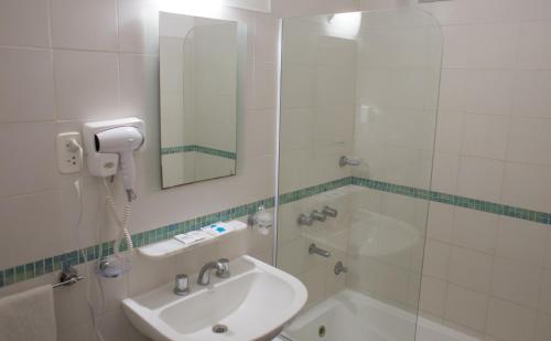 拉巴斯Hotel Milton的一间带水槽、浴缸和镜子的浴室