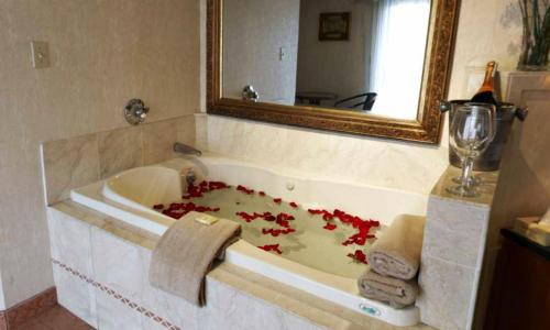 北斯托宁顿锡达帕克酒店的浴室配有装满红花的浴缸。