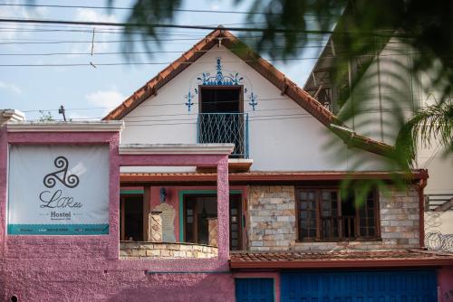布鲁马迪纽Hostel LARes的粉红色和白色的房子,上面有标志
