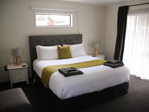 费尔利Mackenzie Motels的一间卧室配有一张大床和毛巾