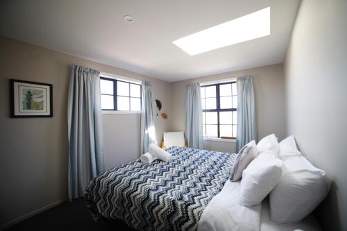 特威泽尔Pedalfish Cottages - Galaxy Views的一间卧室配有带白色枕头的床和窗户。