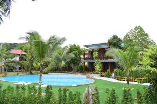 库德岛Markhouse Bungalow Ko Kut的一个带大型游泳池和棕榈树的度假村