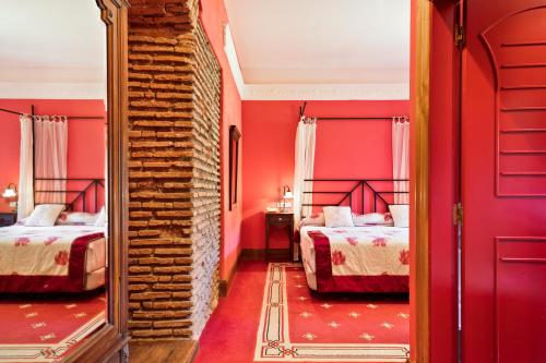 比利亚卡列多阿巴宫德索纳斯酒店的红色卧室设有两张床和镜子
