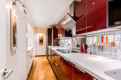 伦敦Garden Apartment in Central London的厨房配有白色台面和红色橱柜