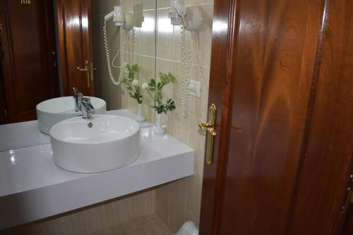 都拉斯阿尔维酒店的浴室设有白色水槽和镜子
