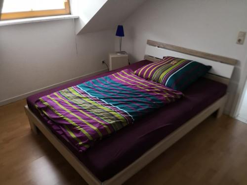 RödentalVilla Mahnberg的卧室内的一张床位,配有紫色棉被