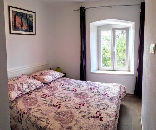 巴比诺波尔杰Holiday apartments Maslina Paho的一间卧室设有一张床和一个窗口