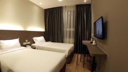 瓜拉立卑U Design Hotel Kuala Lipis的酒店客房设有两张床和电视。