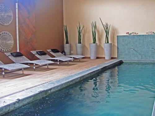 伊利亚贝拉Hotel Itapemar - Ilhabela的一座带躺椅的游泳池位于大楼旁