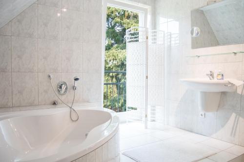 巴特恩豪森Loft auf der Lohe的白色的浴室设有浴缸和水槽。