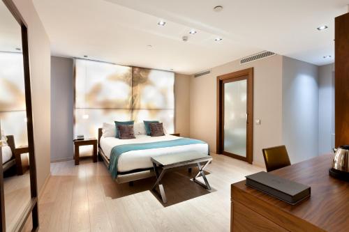 巴塞罗那西班牙兰布拉酒店的一间卧室配有一张床、一张书桌和一个窗户。