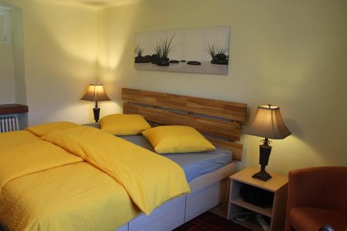 MagadinoCasa Ortensia的一间卧室配有一张带黄床单和两盏灯的床。