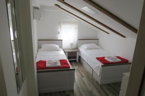 巴斯卡Family Apartment的小客房内的两张床,配有红色床单