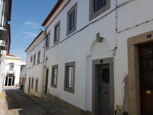 埃武拉A Casa do Mestre的街道上一扇带门的白色建筑
