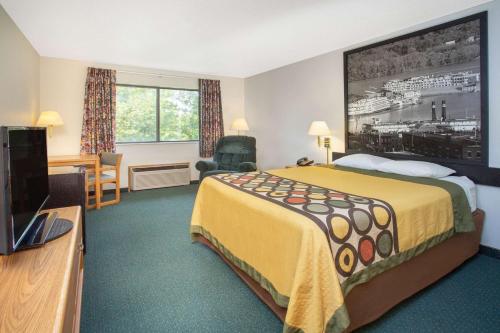 De Witt德威特速8酒店的配有一张床和一台平面电视的酒店客房