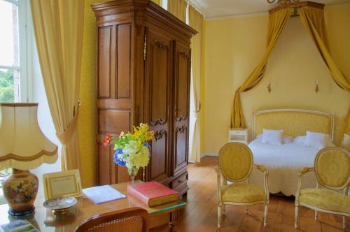 Le Châtellier弗尔蒂埃尔城堡酒店的卧室配有一张床和一张桌子及椅子