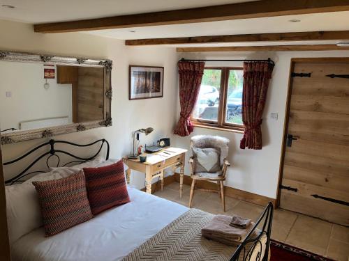 滕特登Finchden Barn的一间卧室配有一张床、一张书桌和一面镜子