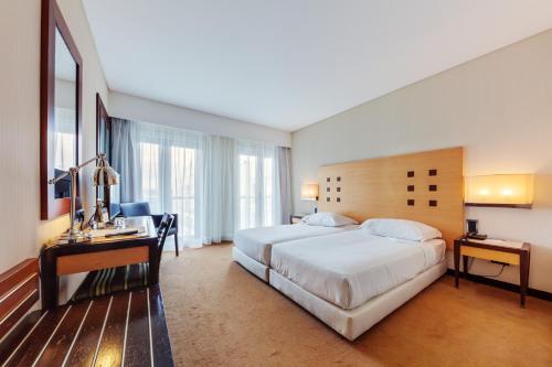 法蒂玛法蒂玛勒克斯酒店的酒店客房设有一张大床和一张书桌。