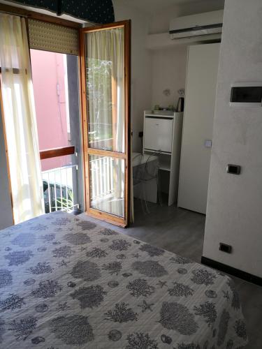 蒙特罗索阿尔马雷阿尔伯格卡鲁吉奥酒店的一间卧室设有一张床和一个滑动玻璃门