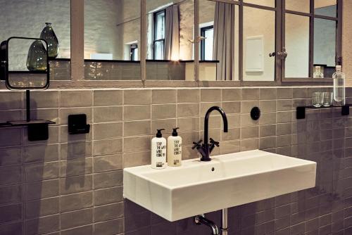 吕贝克Fisher's Loft Hotel的浴室设有白色水槽和镜子