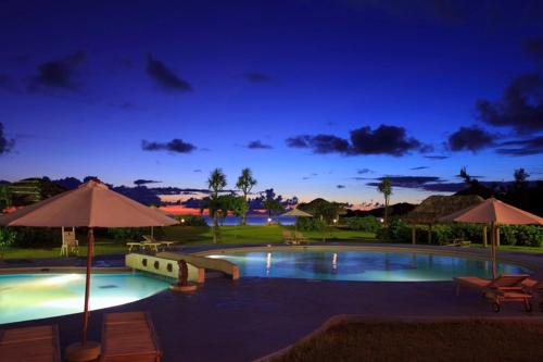 石垣岛石垣海滨酒店的夜间带遮阳伞的游泳池