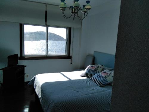 拉科鲁尼亚Primera linea. Vistas al MAR的一间卧室设有一张床和一个窗口