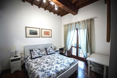佛罗伦萨Luxury central flat river view的一间卧室配有一张床、一张书桌和一个窗户。