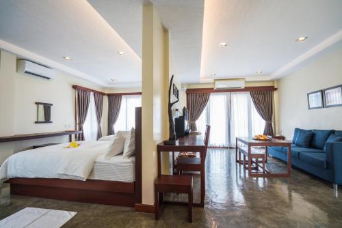 卢纳将军城Retreat Siargao Resort的一间卧室配有一张床和一张蓝色的沙发