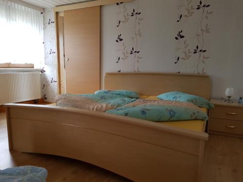 美瑟尔巴赫斯瓦兹姆Ferienwohnung Berndt的一间卧室配有一张带蓝色枕头的床和一扇窗户。