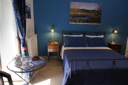 阿格里真托罗拉住宿加早餐酒店的蓝色的卧室,配有床和玻璃桌