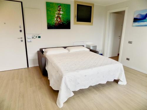 科莫Lake Como view Apartment的一间卧室配有一张带白色毯子的大床