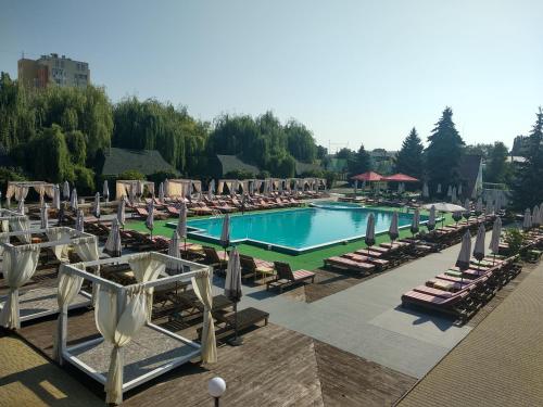 丘宾斯克艾德姆酒店的一个带躺椅和一系列设施的大型游泳池