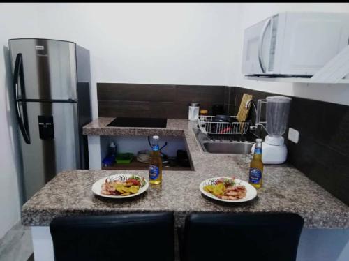 洛佩斯港Monte Líbano Suites的厨房在柜台上放两盘食物